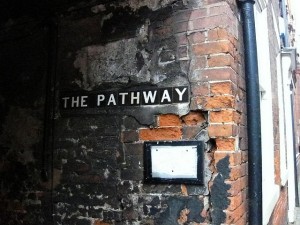 burnt brick wall with words The Pathway on it
