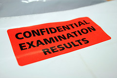 black letters on orange background stating -- confidential examination results