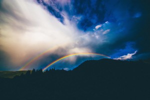 double rainbow over mountains in distance with clouds